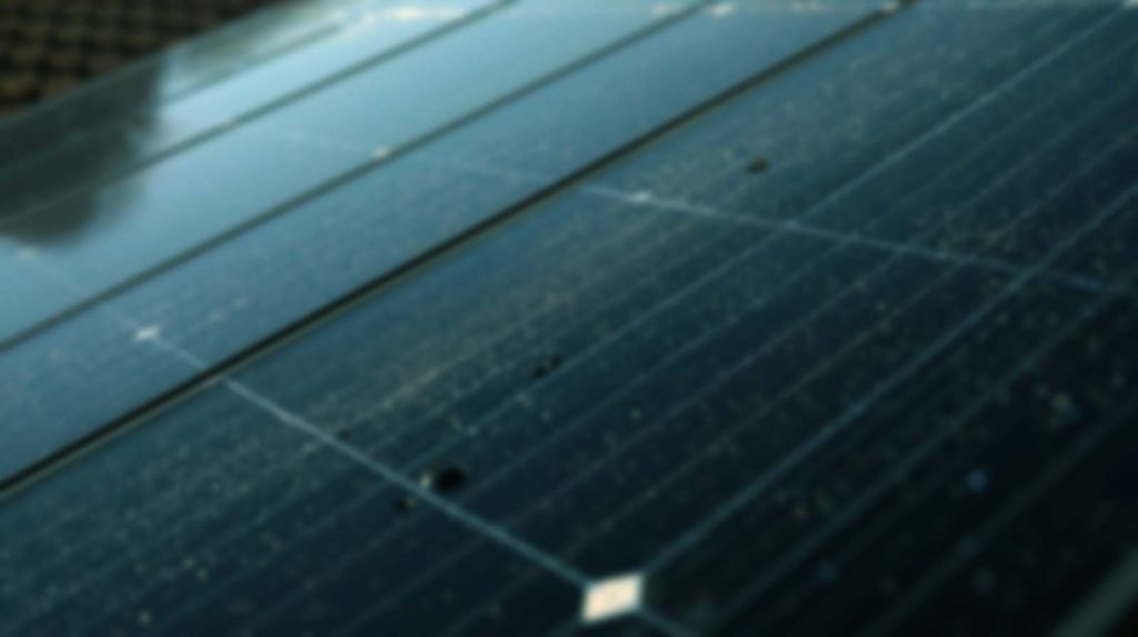 Poros és szennyezett felületű napelem panel közelről, ahol a lerakódott por és szennyeződés csökkentheti az energiatermelés hatékonyságát. Miért fontos a napelem tisztítása.